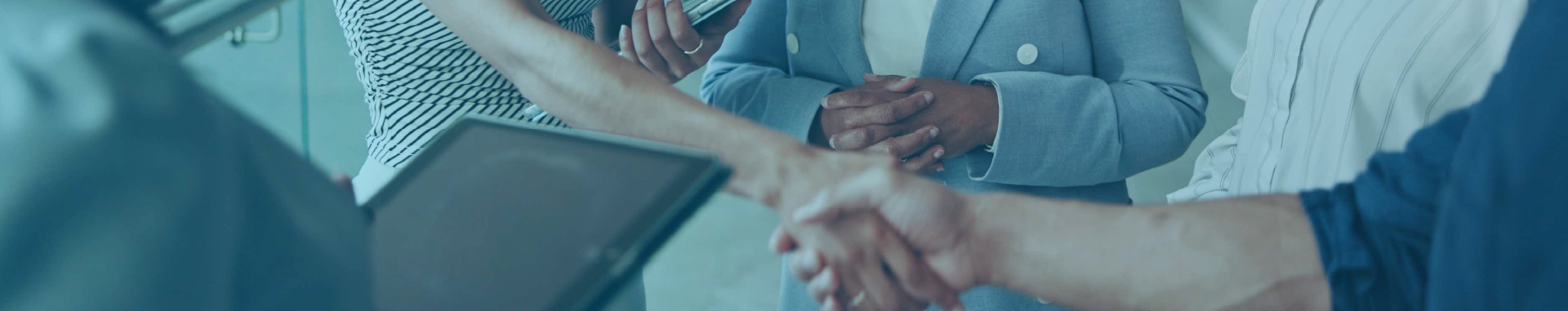 Business professionals shaking hands at a networking event, symbolizing partnership and collaboration opportunities.