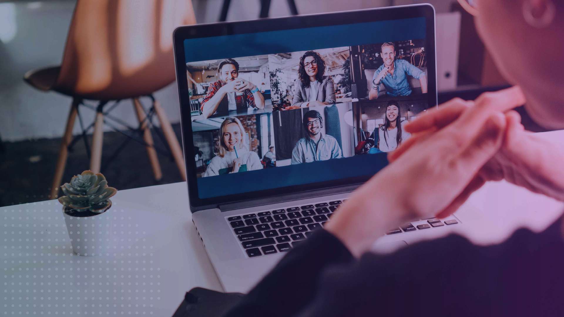Person participating in a virtual summit on a laptop, with multiple speakers visible in a video conference grid during an online session.