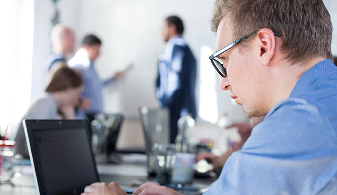 Image of a man working at a laptop